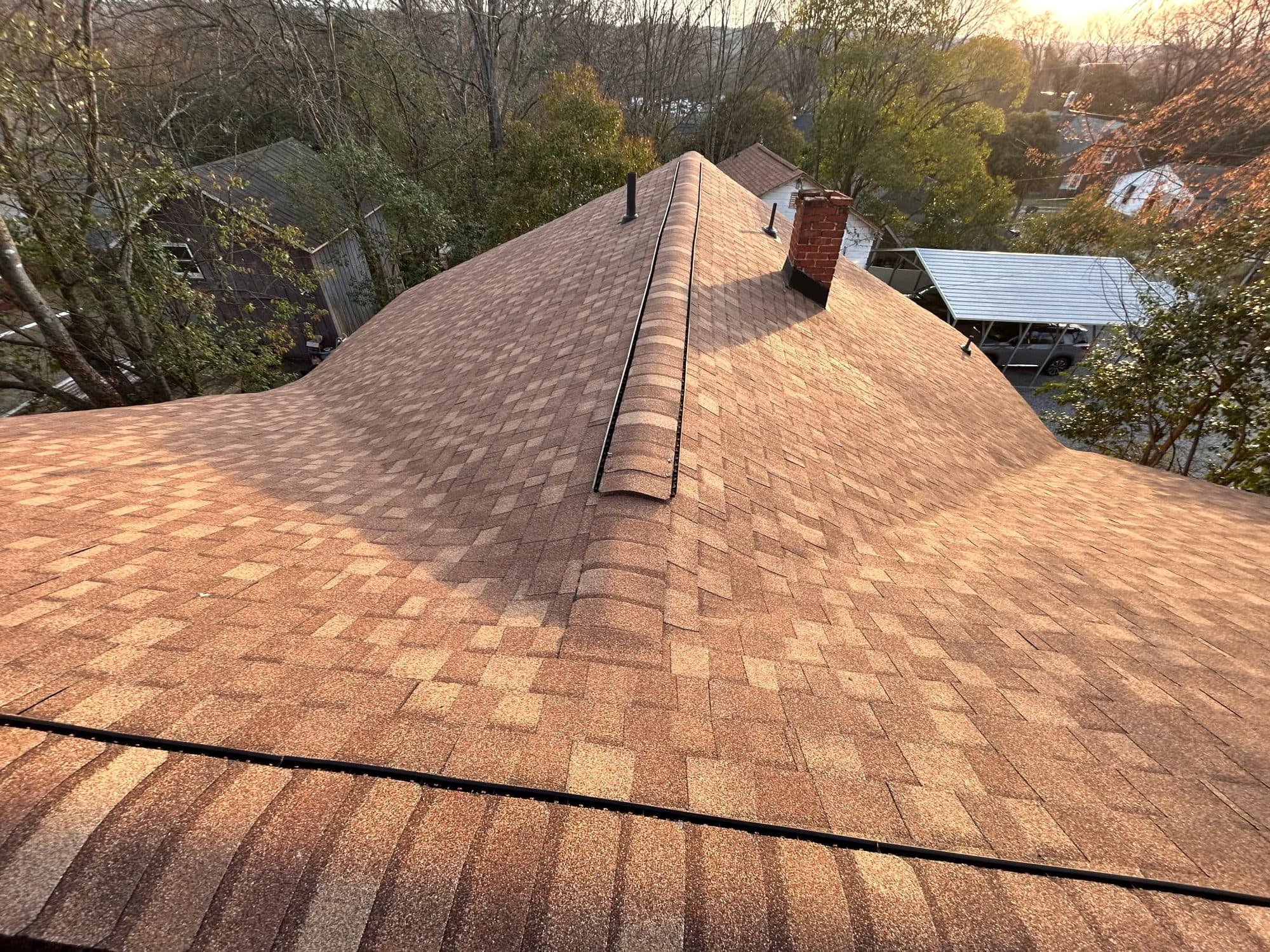 New warm brown asphalt shingle roof with continuous ridge vent on a Concord NC home