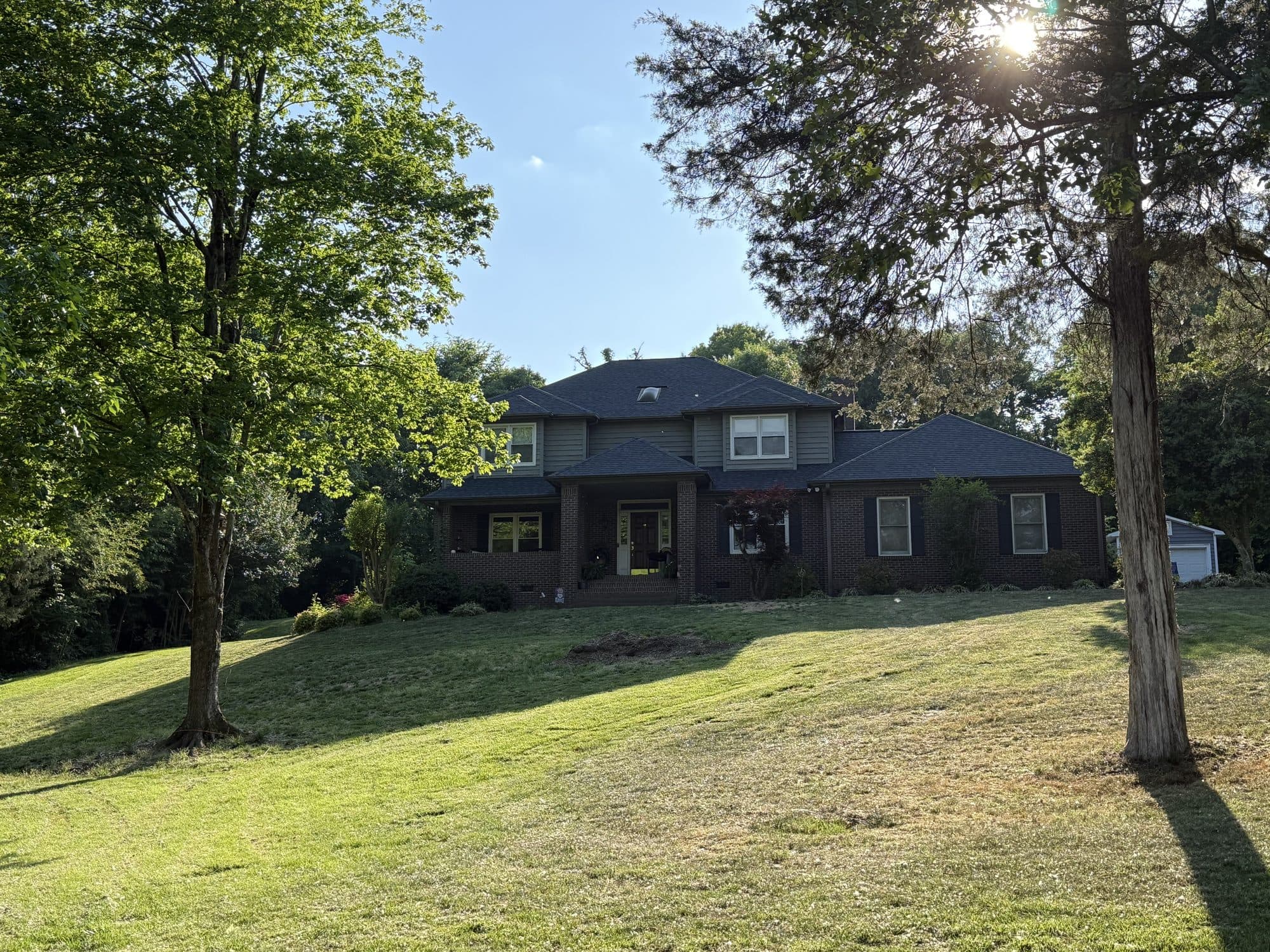 Two-story brick home with a new charcoal asphalt shingle roof
