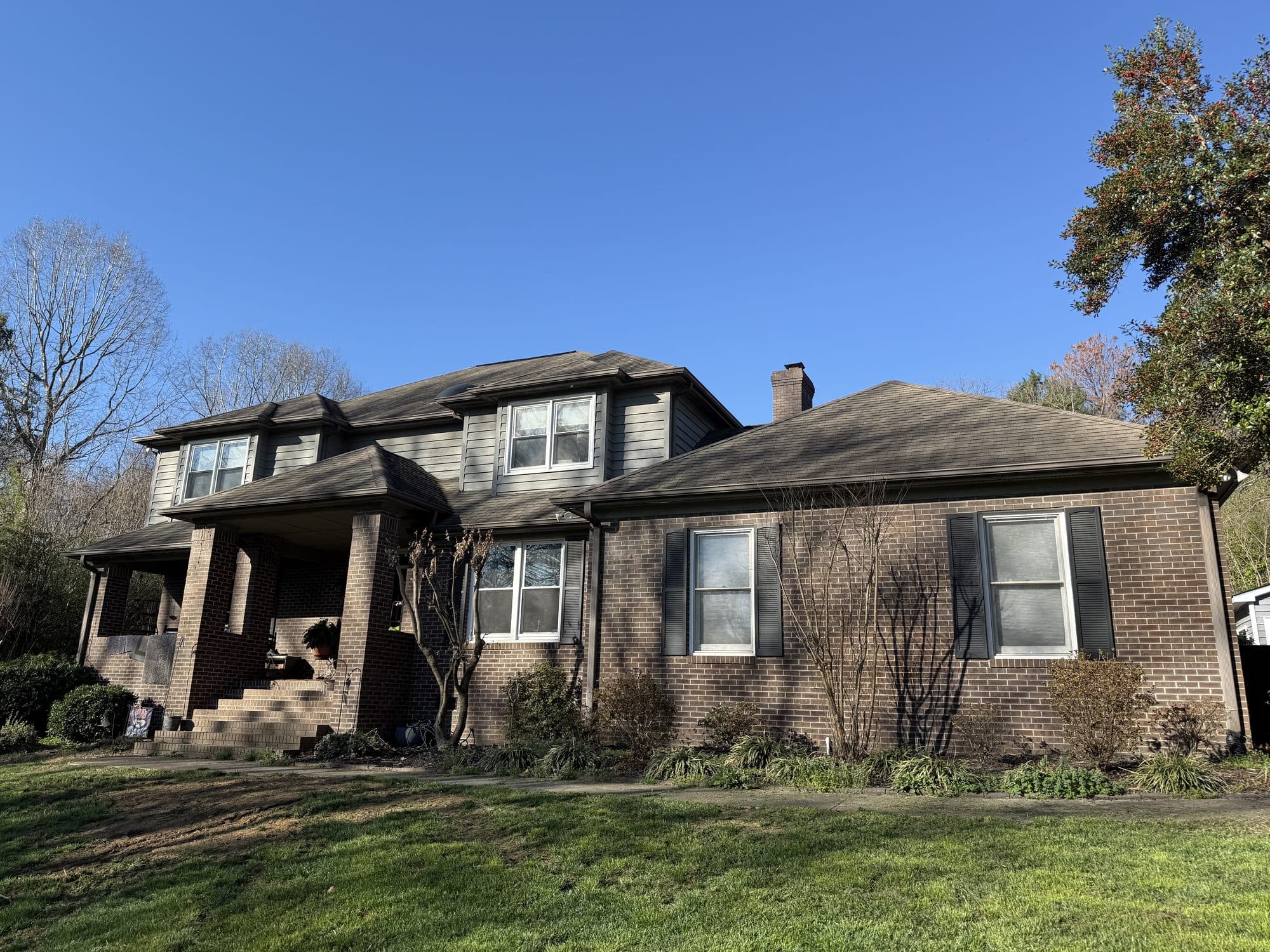 Two-story brick home before roof replacement
